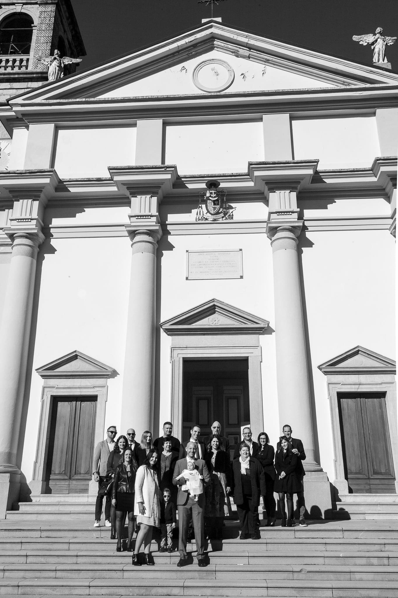 In bianco e nero, il gruppo di parenti e amici posa sulla scalinata davanti alla facciata neoclassica della chiesa